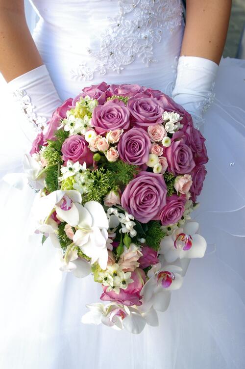 新娘捧着华丽的婚礼玫瑰花束