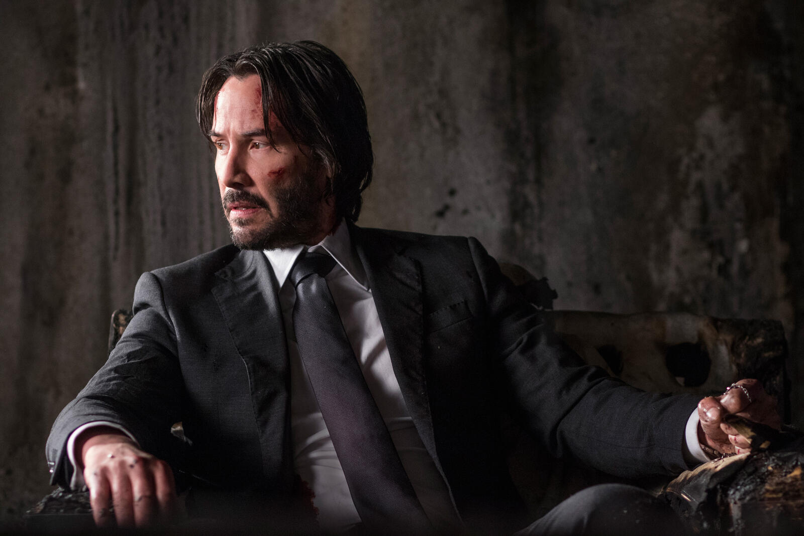 Free photo John Wick sits in a chair wearing a jacket