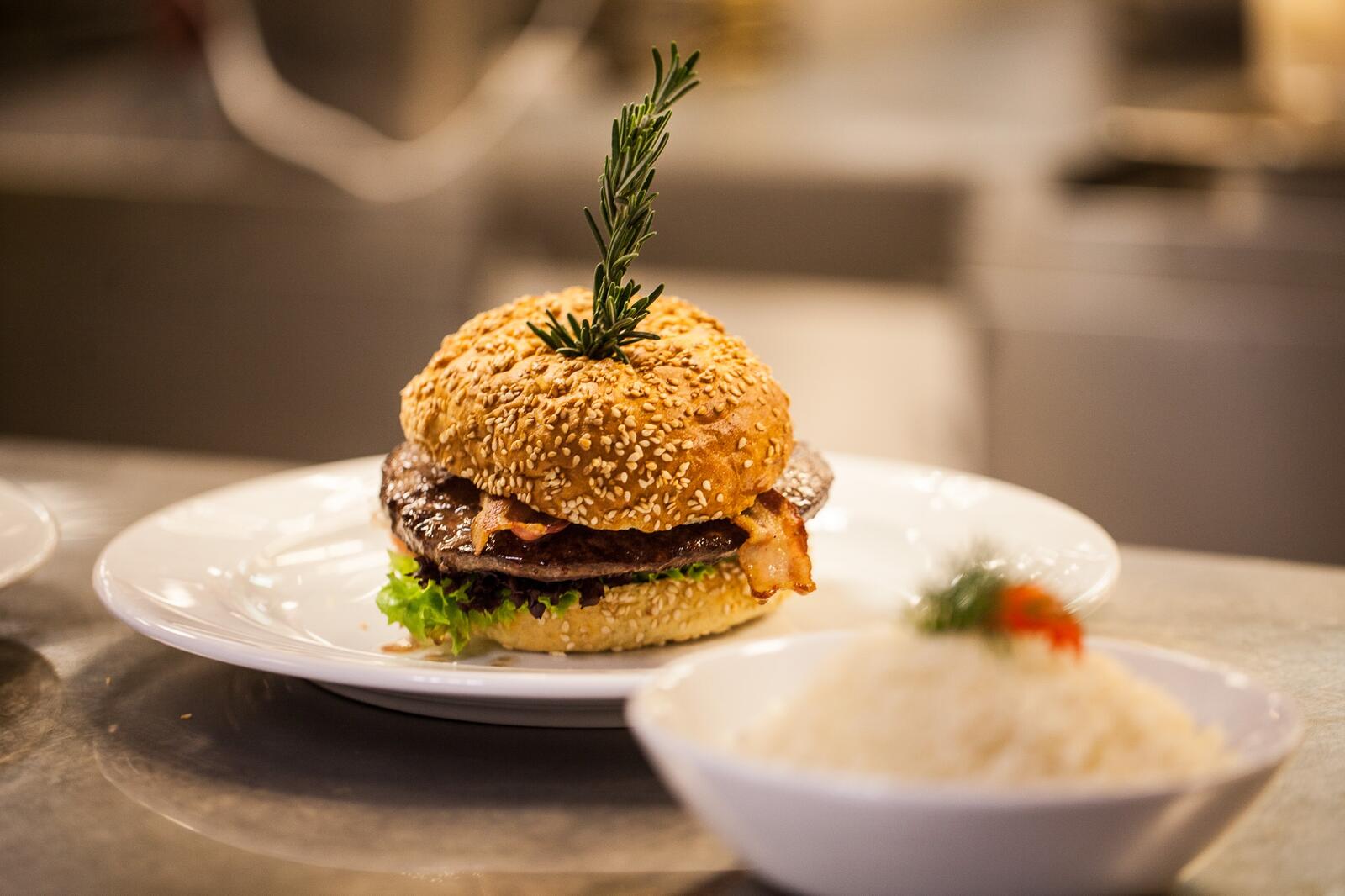 Бесплатное фото Гамбургер на белой тарелке в ресторане