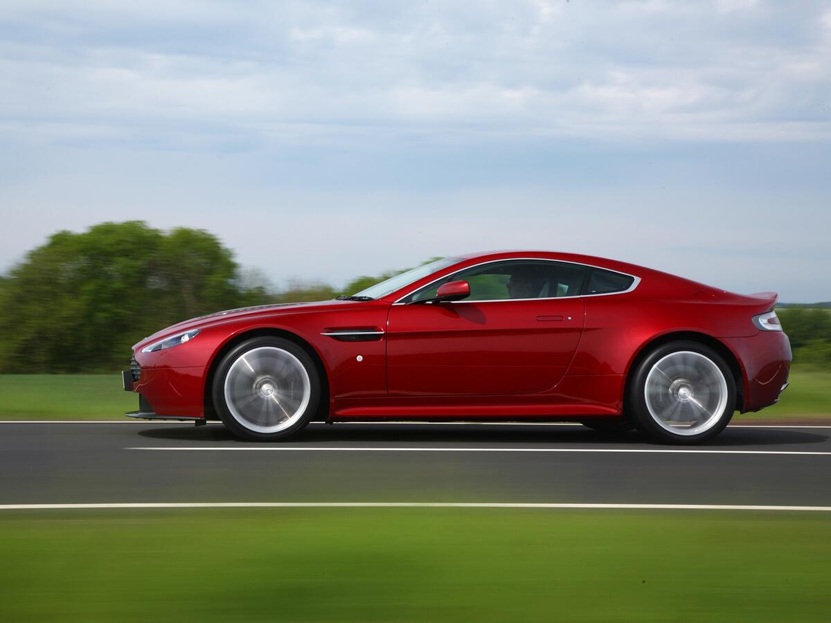 Aston Martin DB9 красного цвета в движении