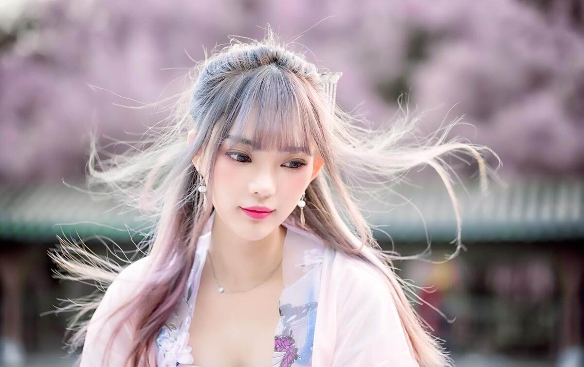 Девушка с азиатской внешностью с развивающимися волосами на ветру