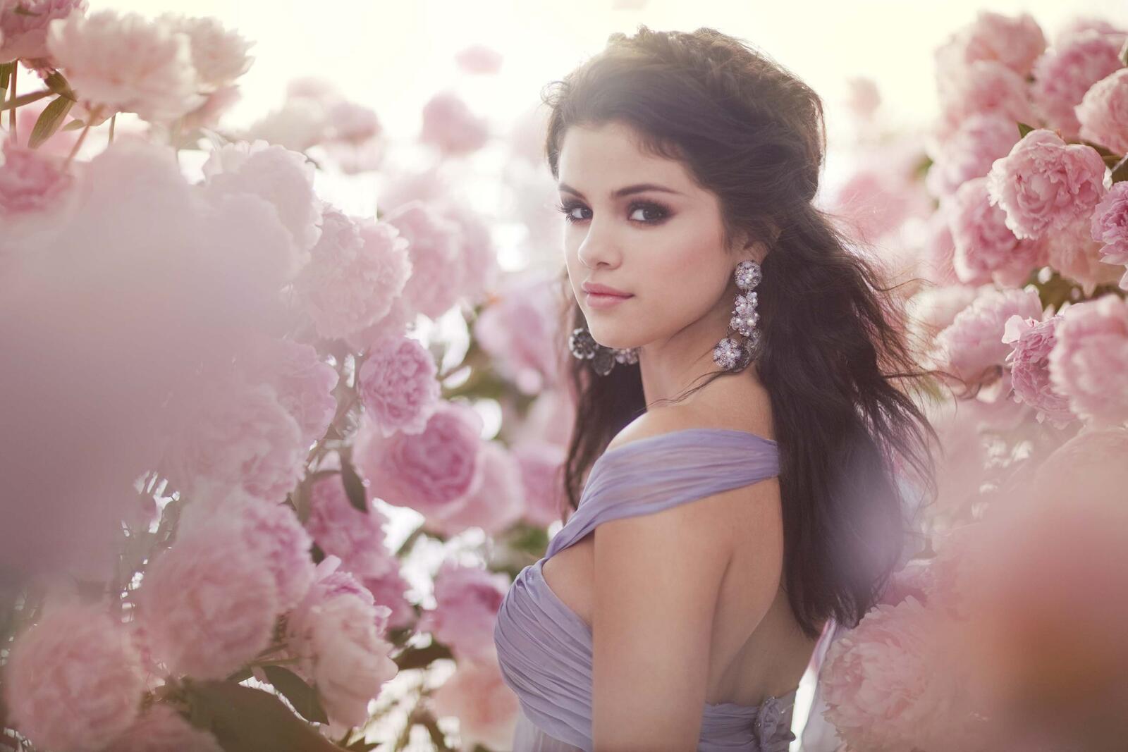 Free photo Selena Gomez in the garden with pink flowers