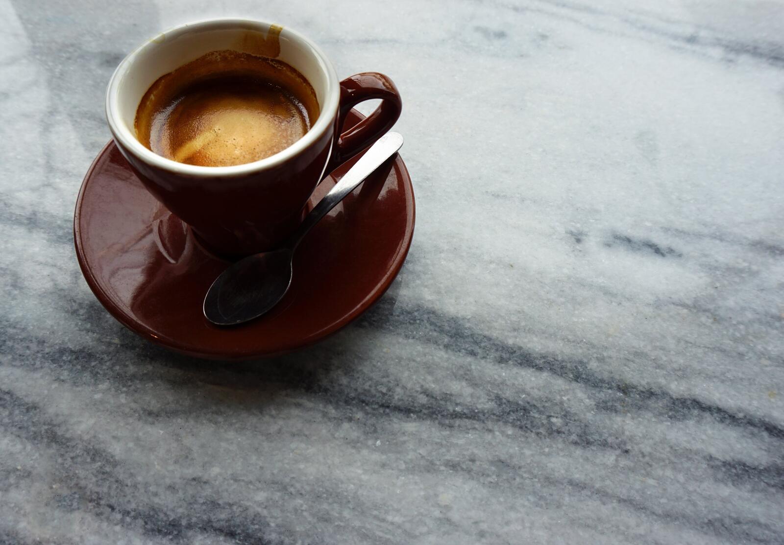 Бесплатное фото Коричневая чашка кофе стоит на каменном столе