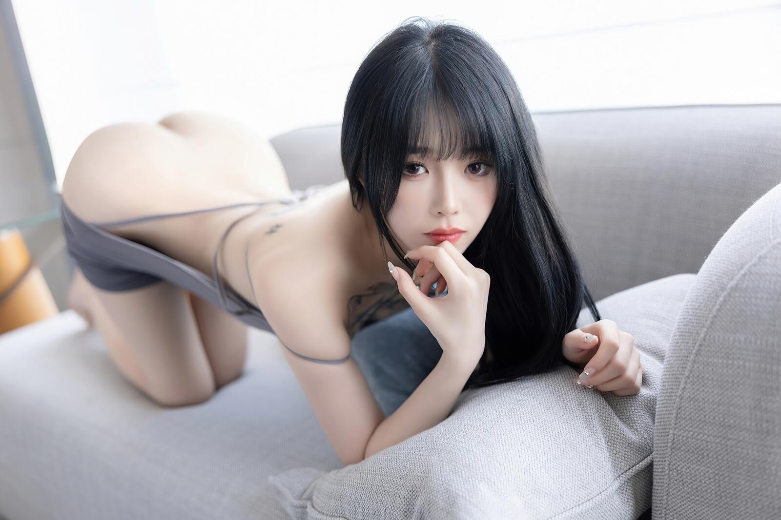 Бесплатное фото Симпатичная китаянка с голой попкой на диване
