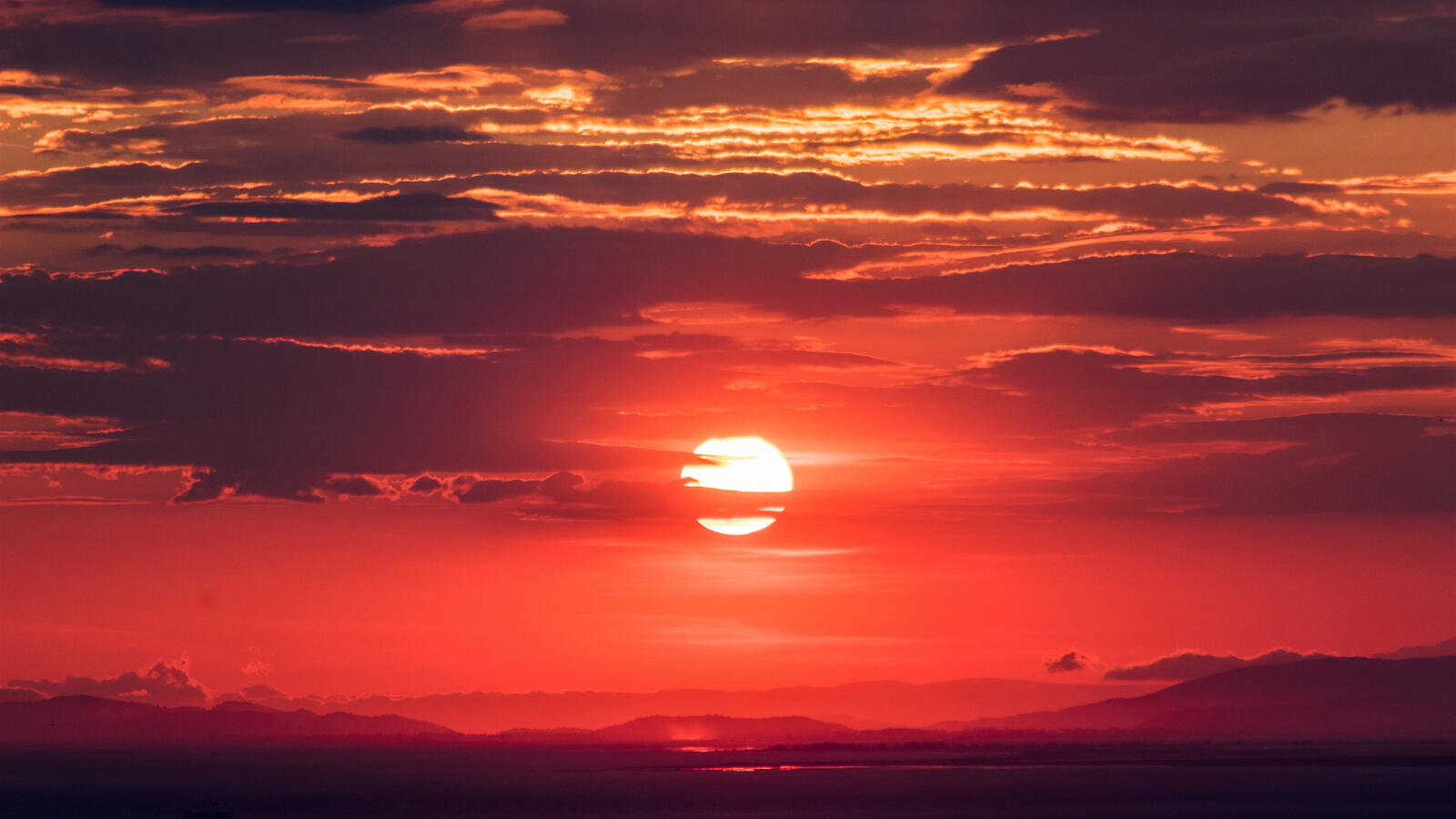 Бесплатное фото Красное солнце на облачном небе