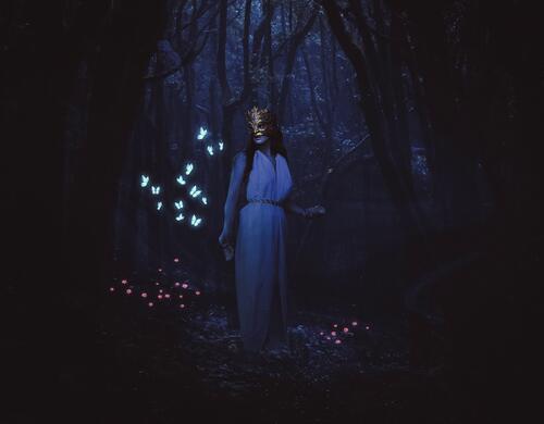 Девушка в маске в тёмном лесу