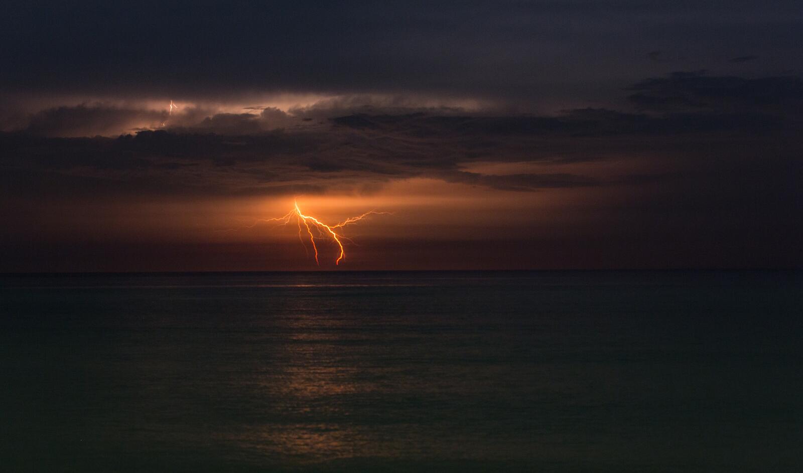 Бесплатное фото Ночная молния над океаном