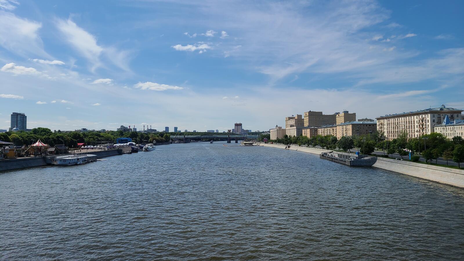 Бесплатное фото Городская река с причалом и арочным мостом