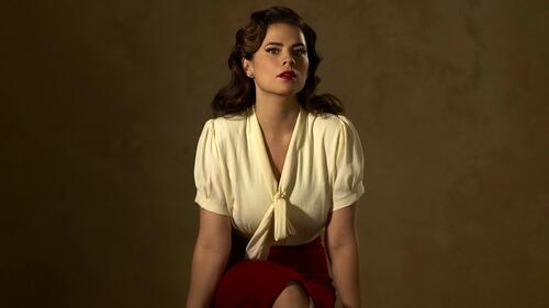 Actress Hayley Atwell sits against a dark background