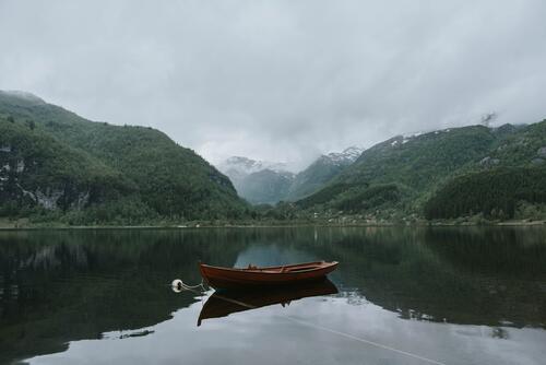 A picture of a lone wooden boat on a lake