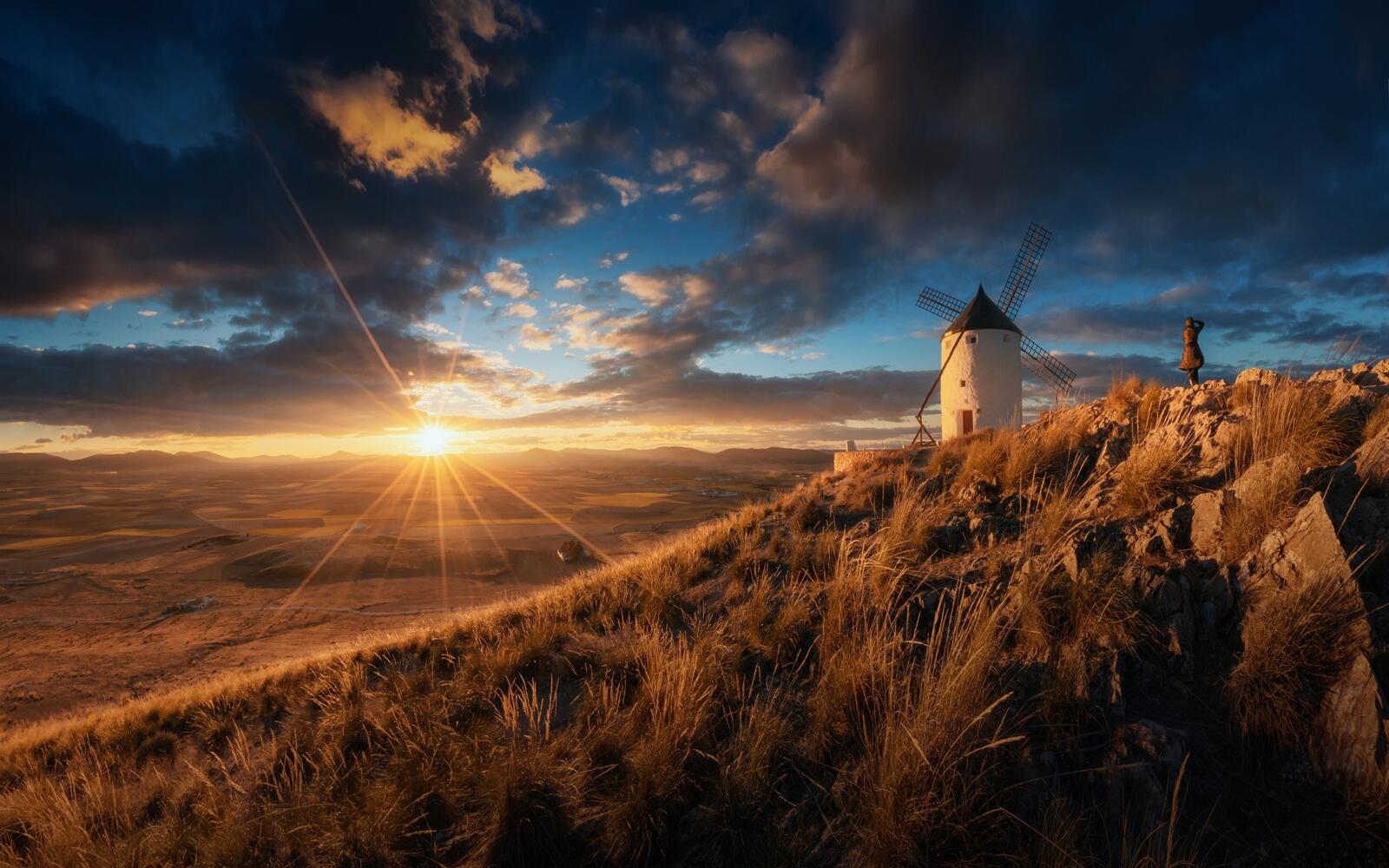 Бесплатное фото Мельница на горе во время заката