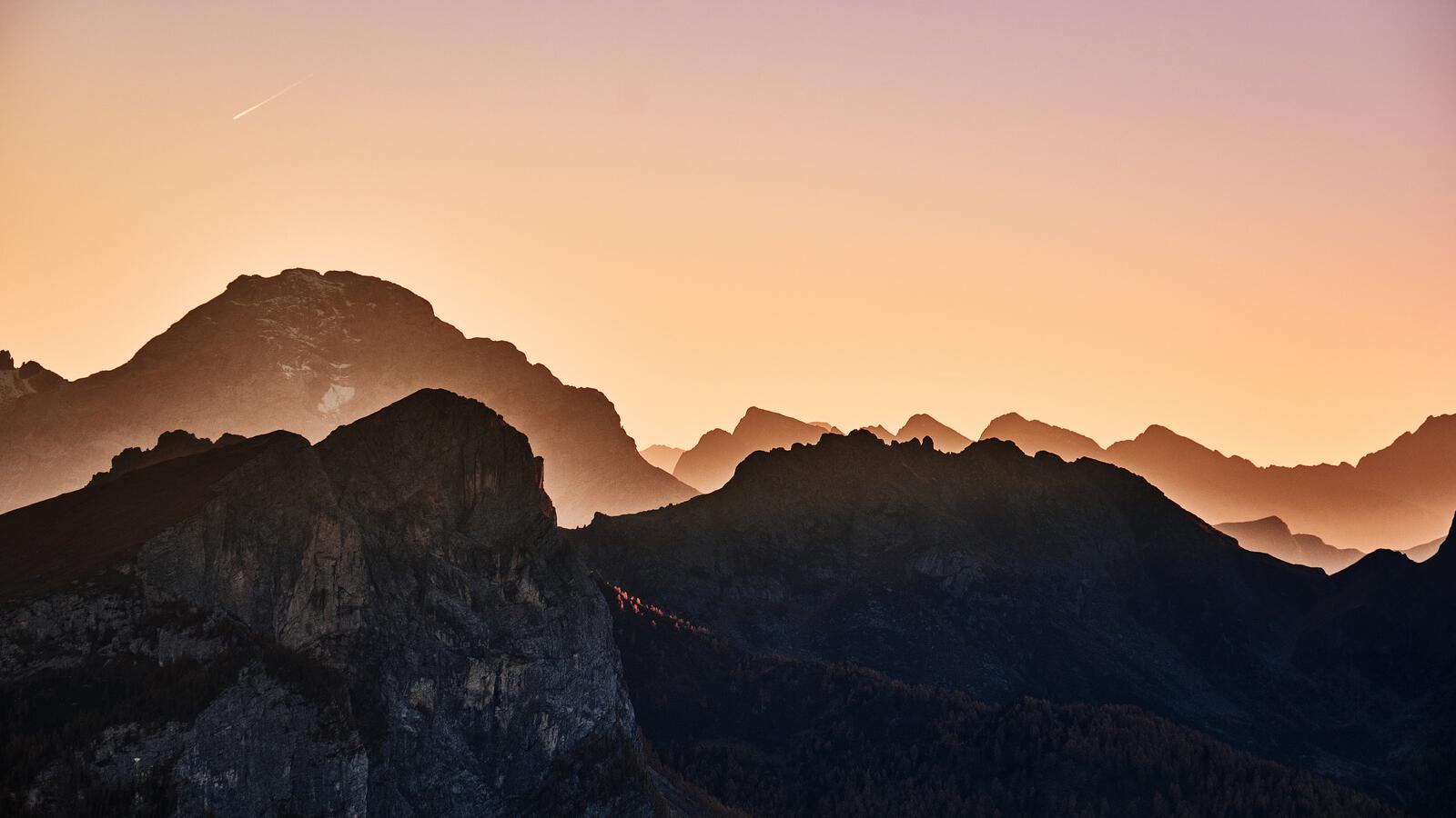 Бесплатное фото Холмы гор на фоне красочного неба с падающий звездой