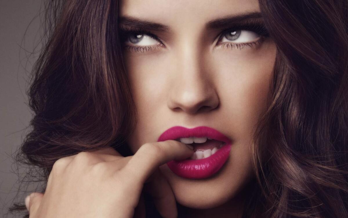 A pensive Adriana Lima with pink lips