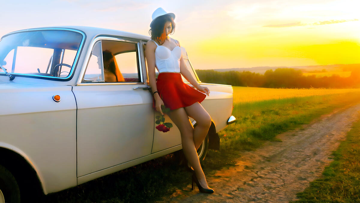 The girl in the red skirt and panama by the old white car.