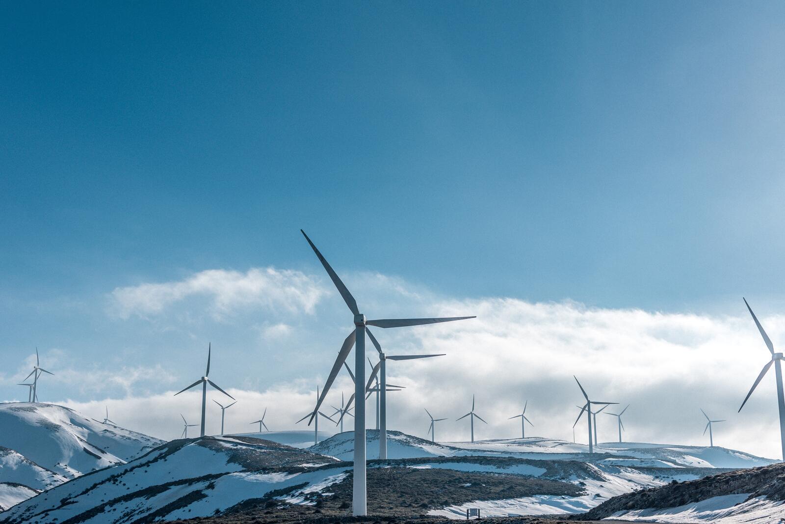 Бесплатное фото Ветряные мельницы на вершинах гор зимой