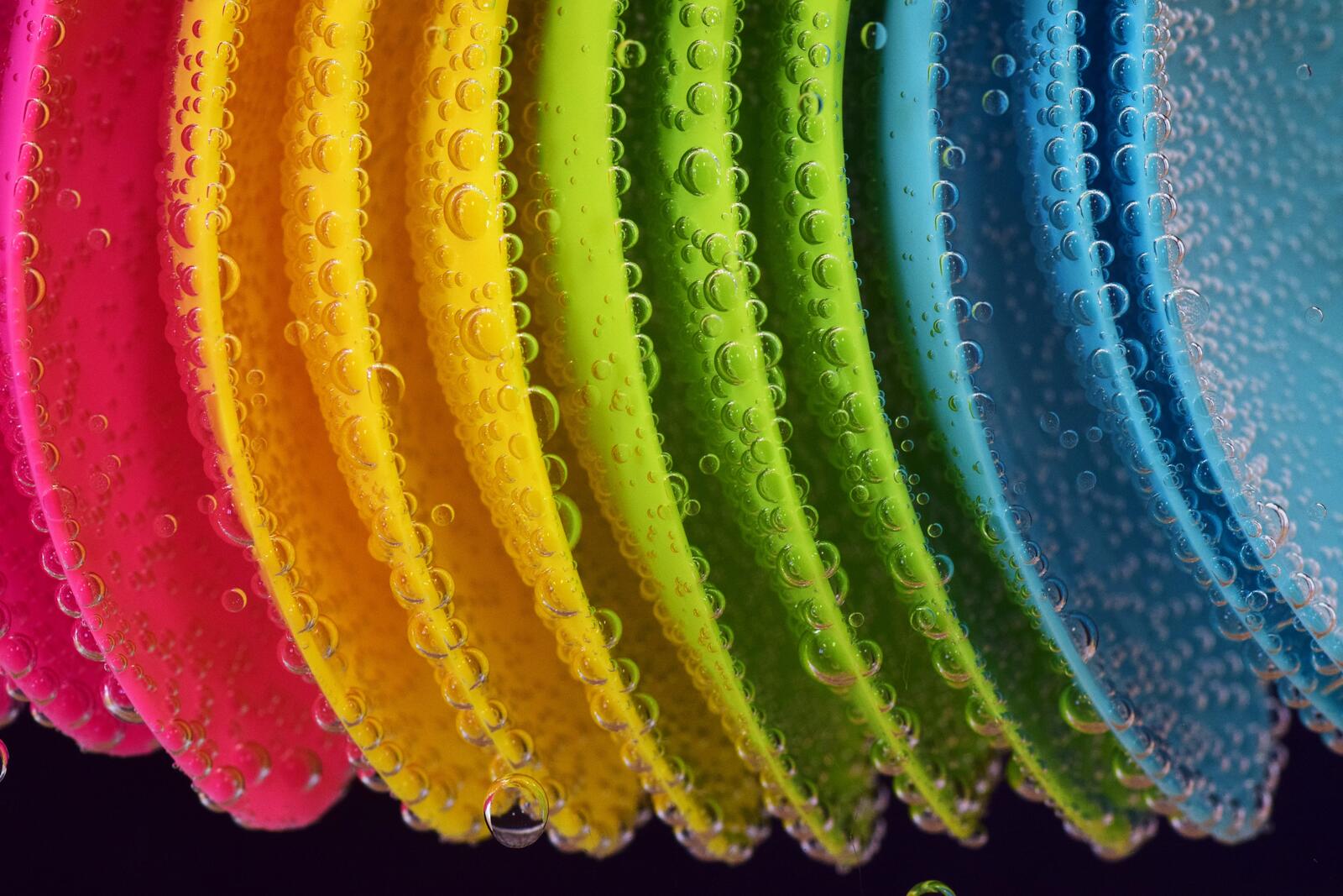 Free photo Colored plastic spoons in water