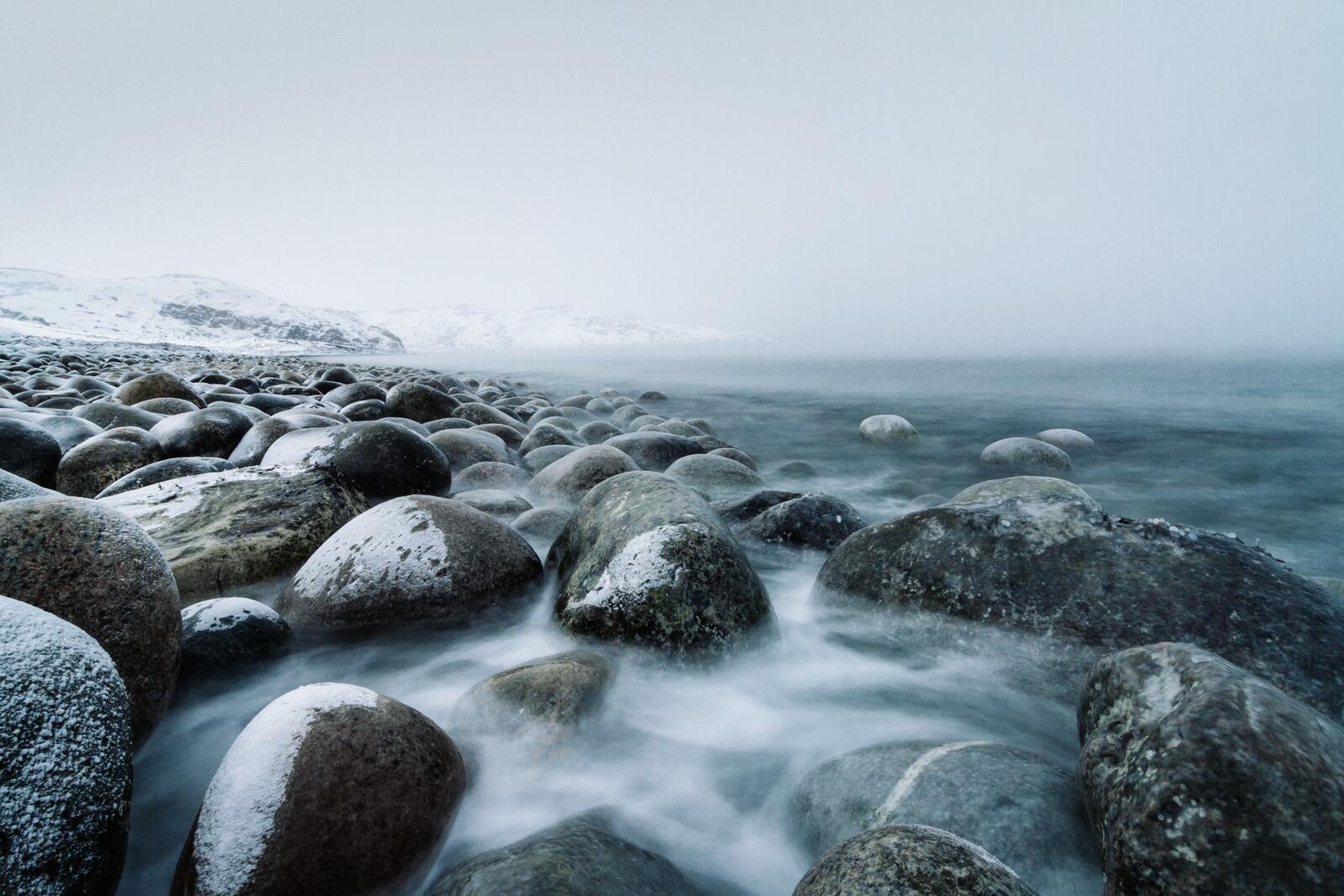 Бесплатное фото Камни на морском берегу покрытые снегом