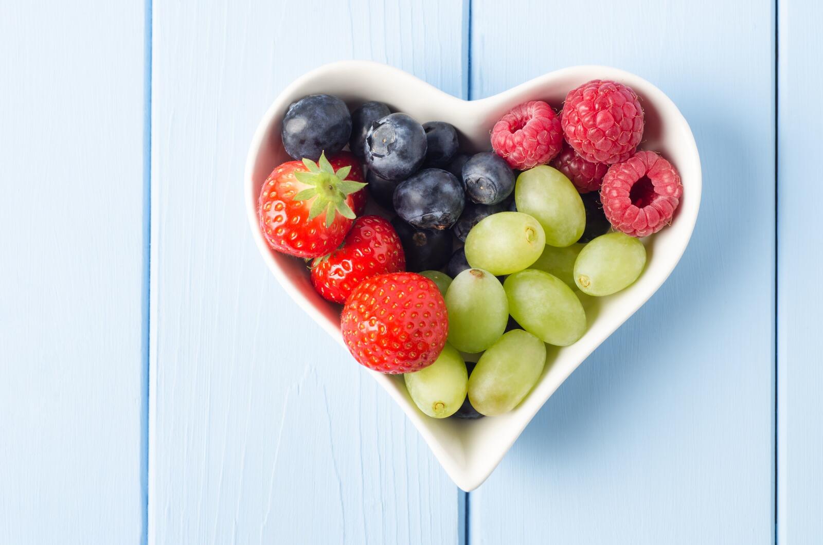 Бесплатное фото Тарелка в форме сердечка с ягодками