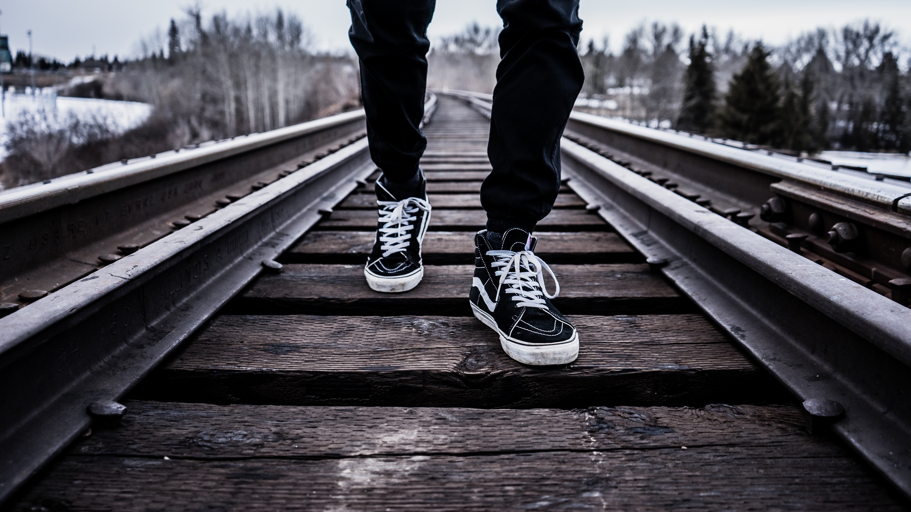 一名穿着运动鞋的男子正沿着铁路行走