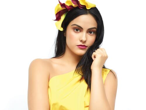 Camila Mendes in a yellow dress on a white background