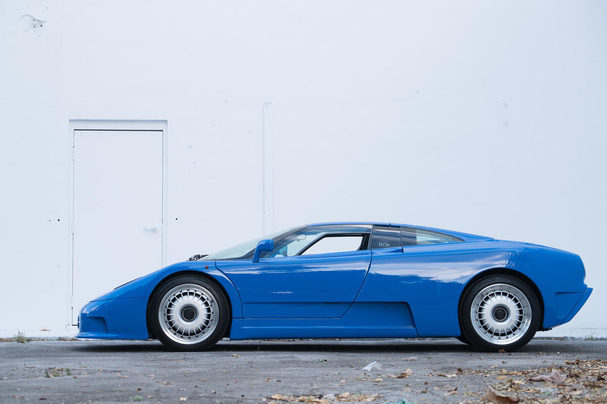 Blue bugatti eb110 against a white wall