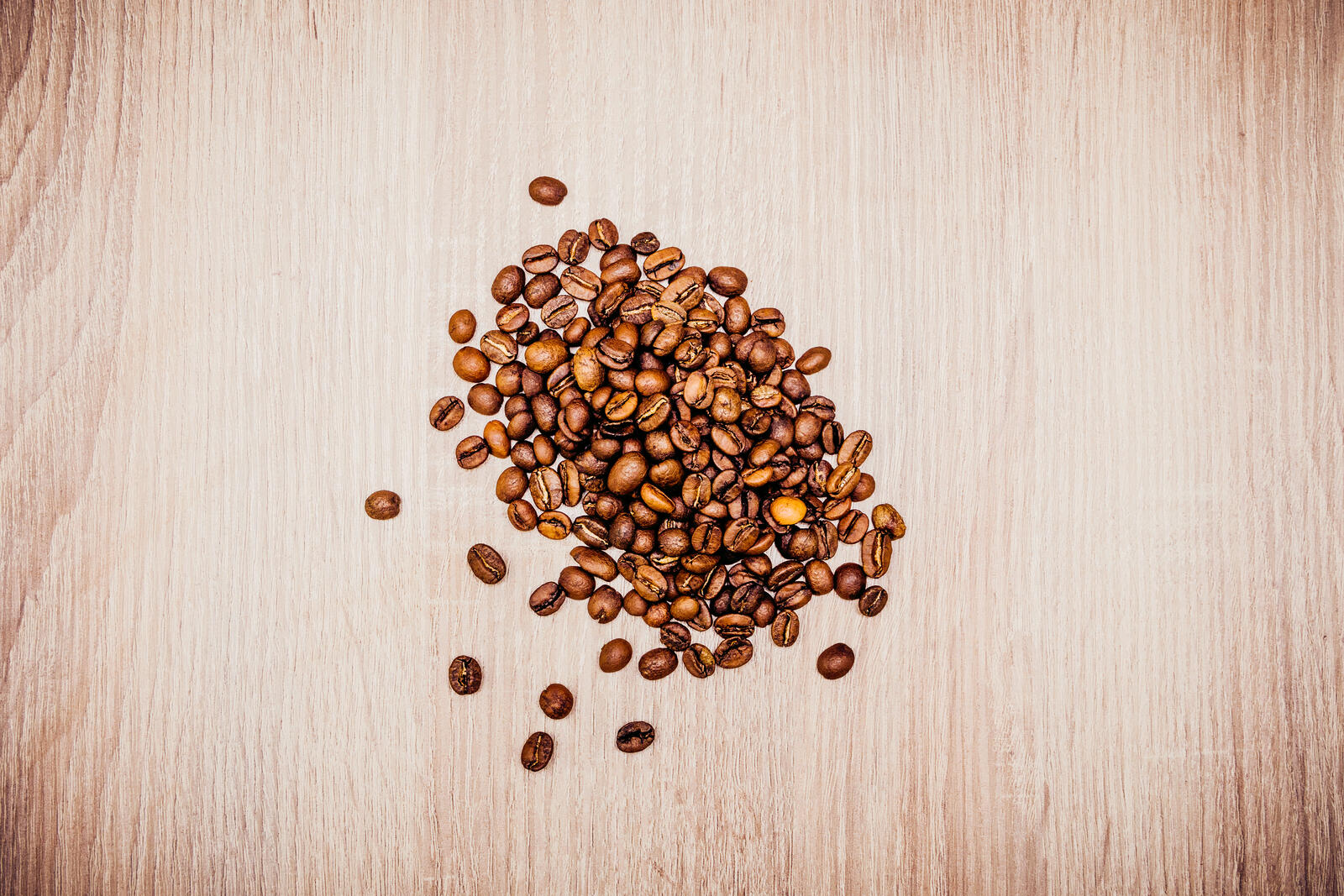 Free photo Coffee beans on a wooden background
