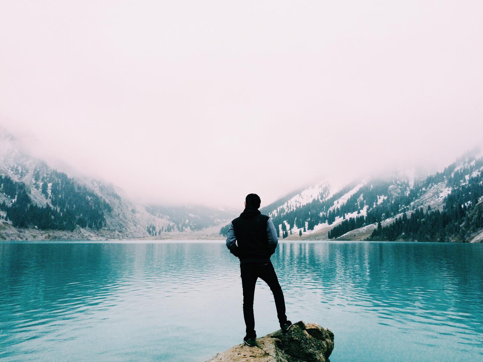 Бесплатное фото Парень смотрит на голубую воду в озере