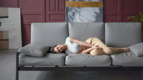 Девушка отдыхает на сером диване