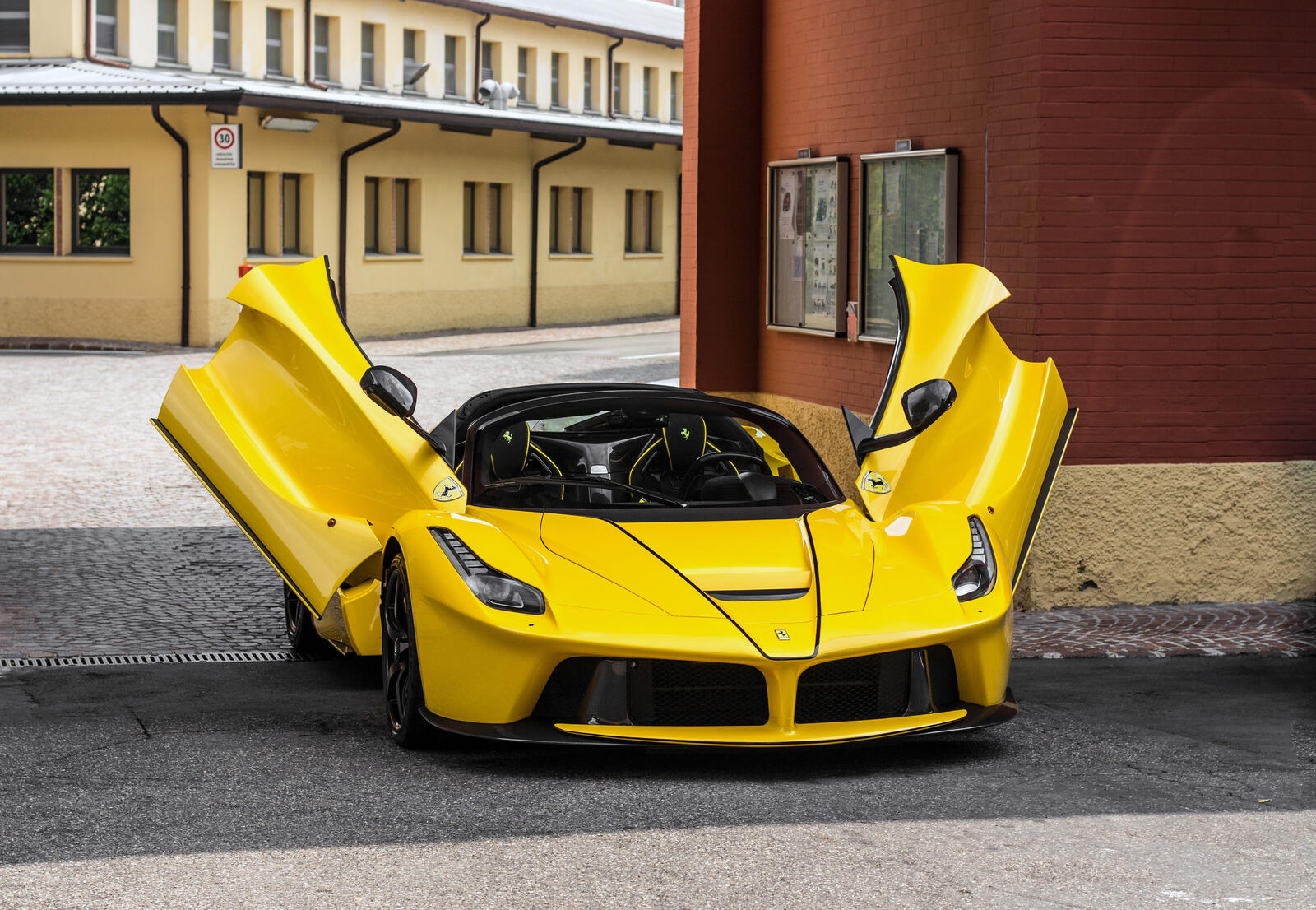 Free photo A yellow Laferrari with the doors open.