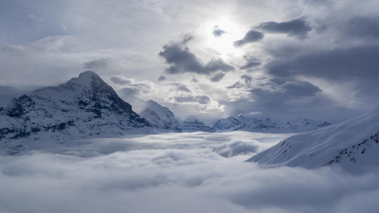 Free photo Mountains in Switzerland covered in snow are hidden by fog