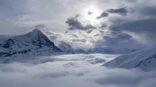 Mountains in Switzerland covered in snow are hidden by fog