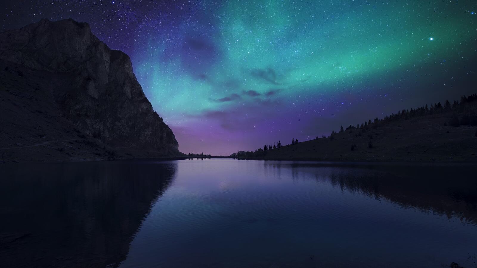 Бесплатное фото Красивое фиолетовое северное сияние над рекой