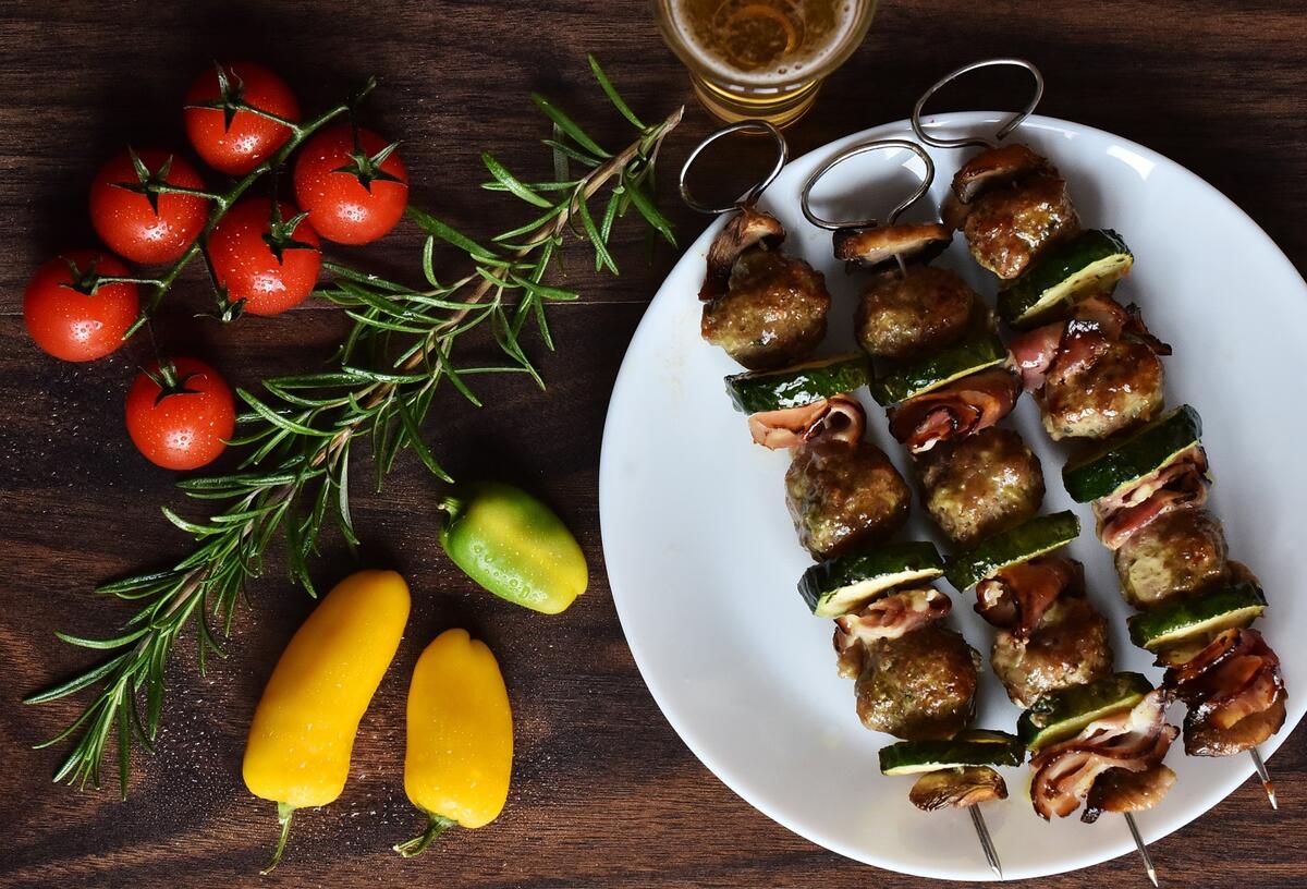 Shish kebab with cucumbers on a white plate