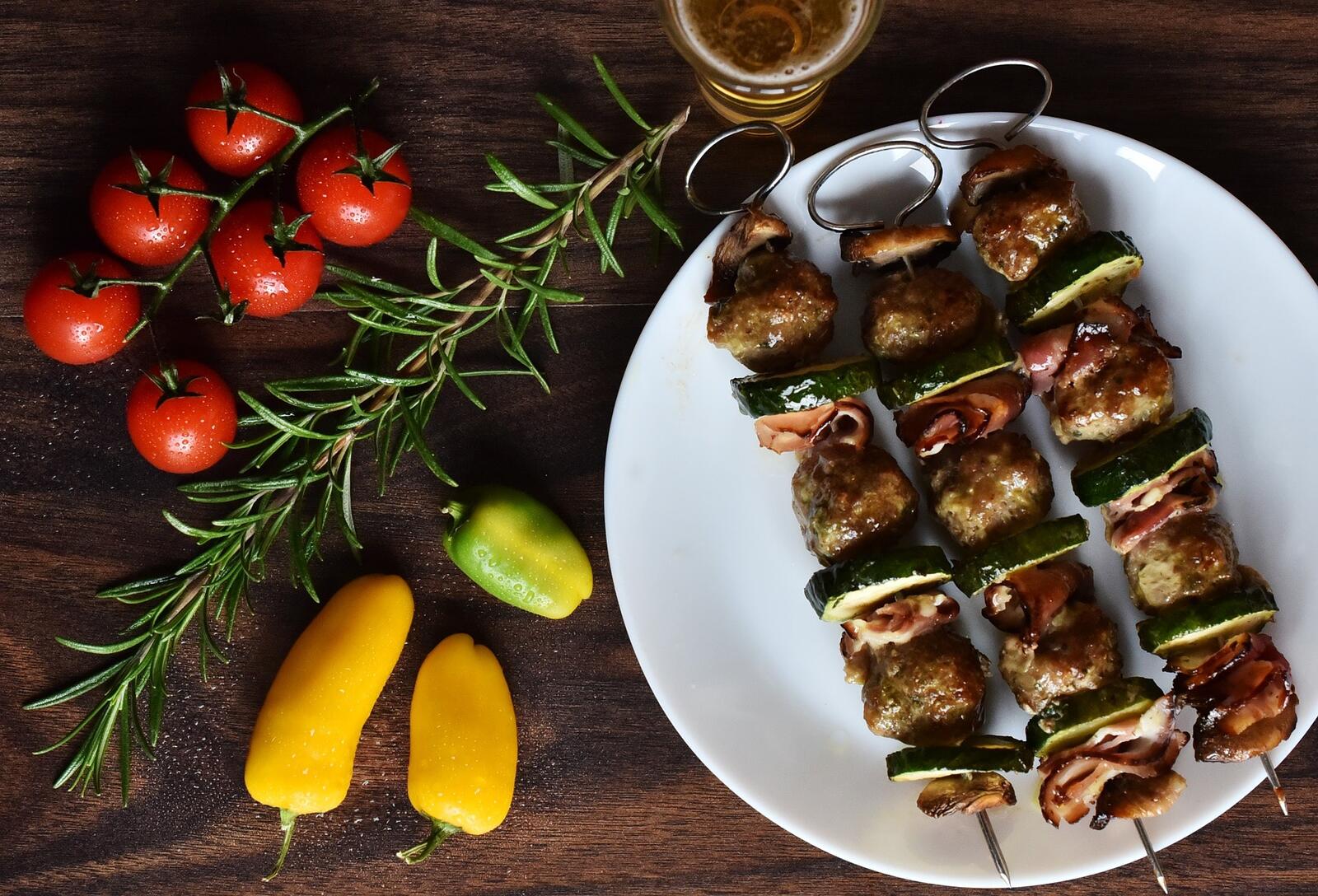 Free photo Shish kebab with cucumbers on a white plate