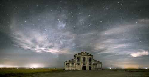 Beautiful night sky with stars over an abandoned house