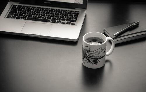 Desktop with a laptop and a cup of coffee