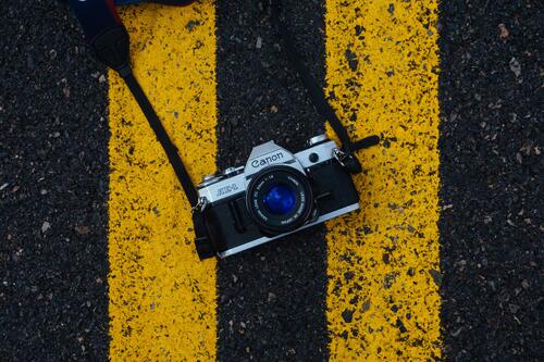 A single-lens reflex camera lying on the pavement