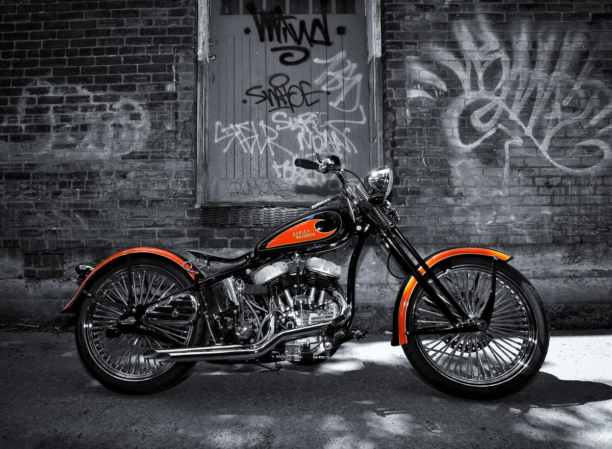 Black and white photo of Harley Davidson with orange elements