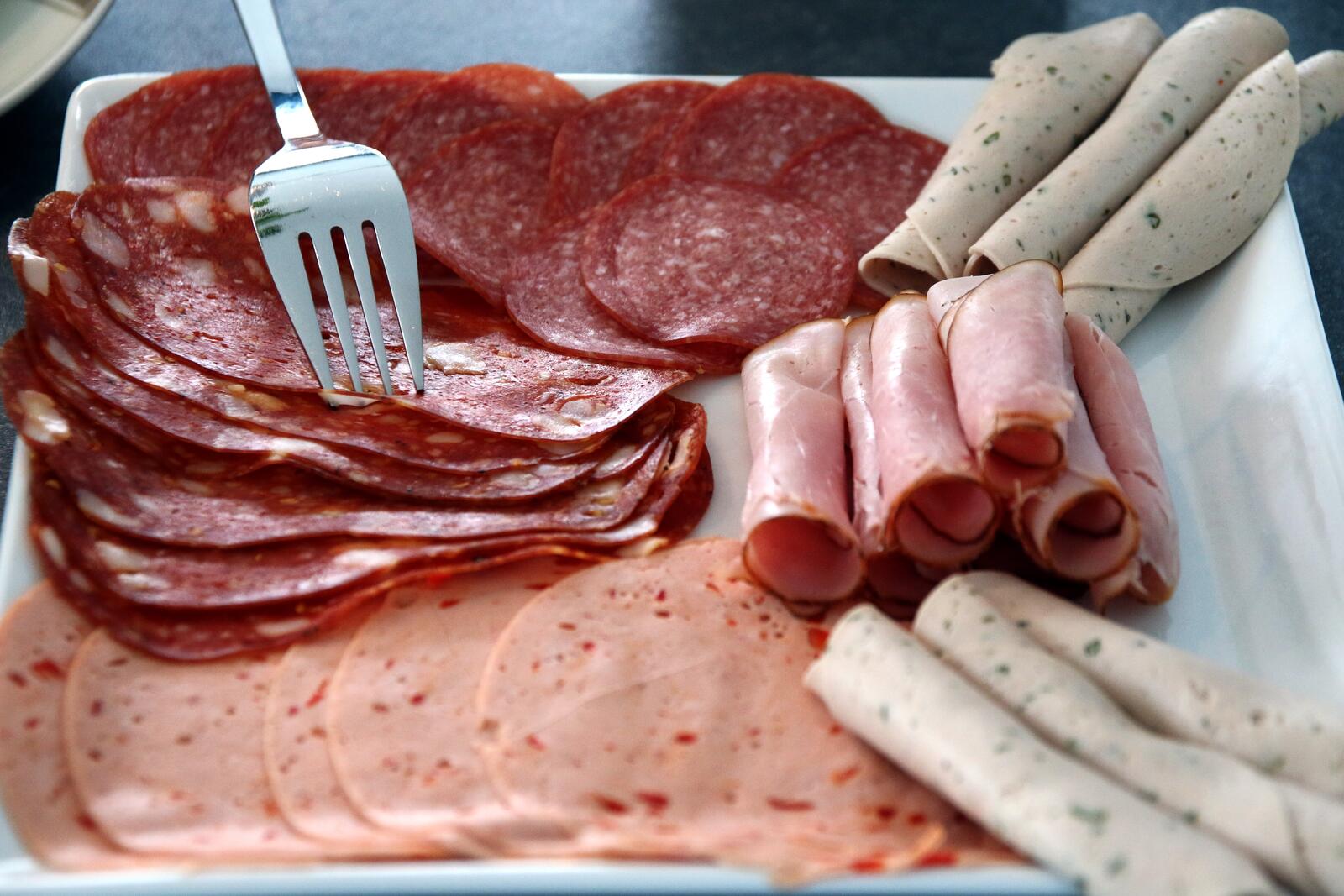 Бесплатное фото Тонко порезанные кусочки колбасы