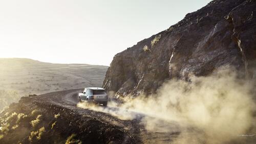Range Rover едет по пыли в горах