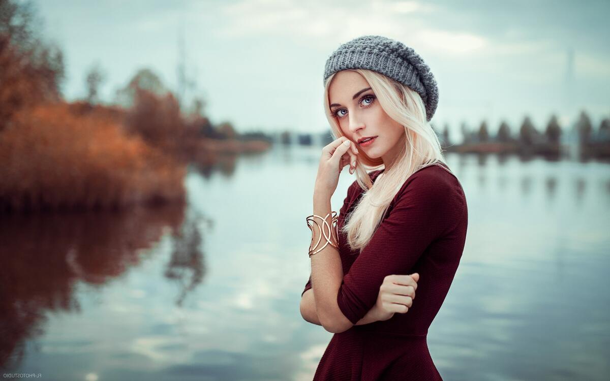 A girl in a red dress with a knit hat.