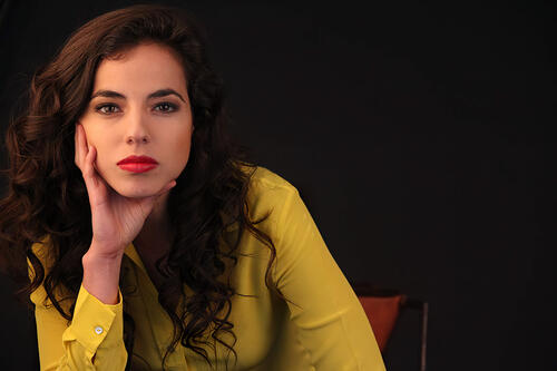 Christina Rodlo in a yellow blouse on a black background