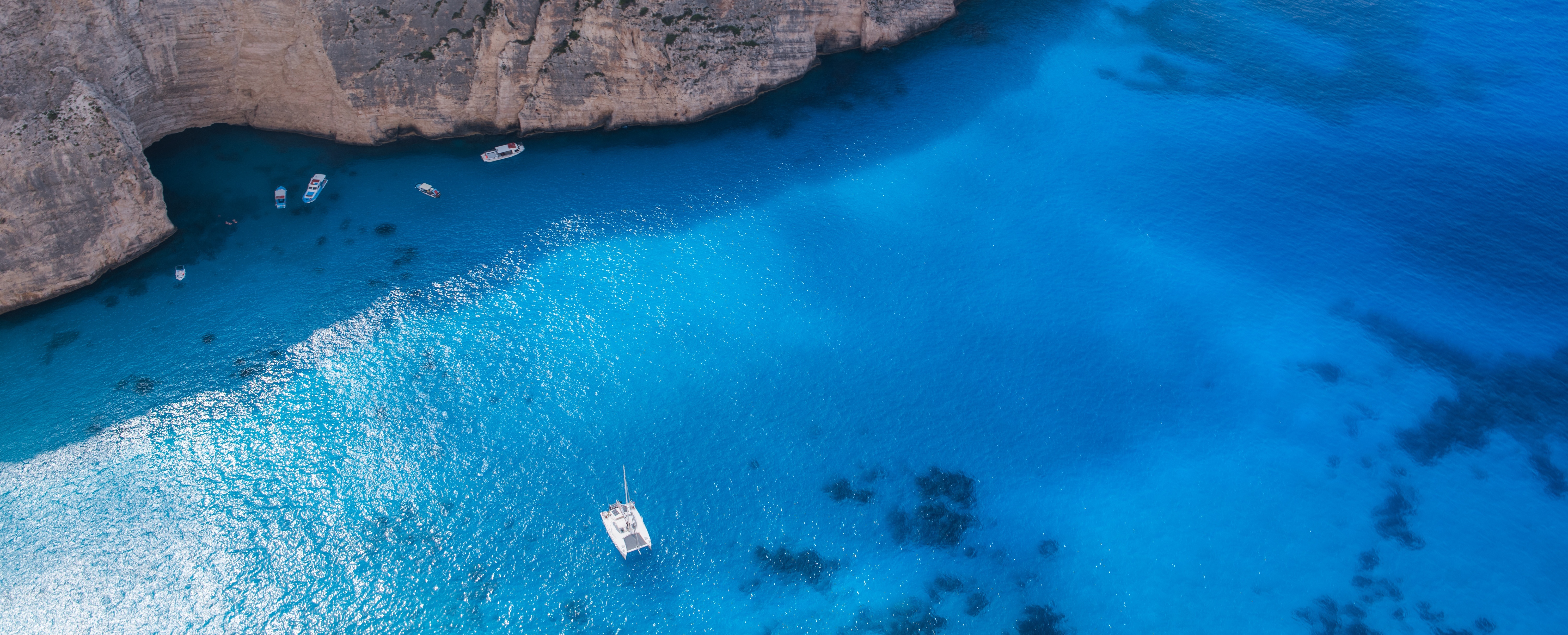 免费照片一幅蓝色泻湖中孤独帆船的照片。