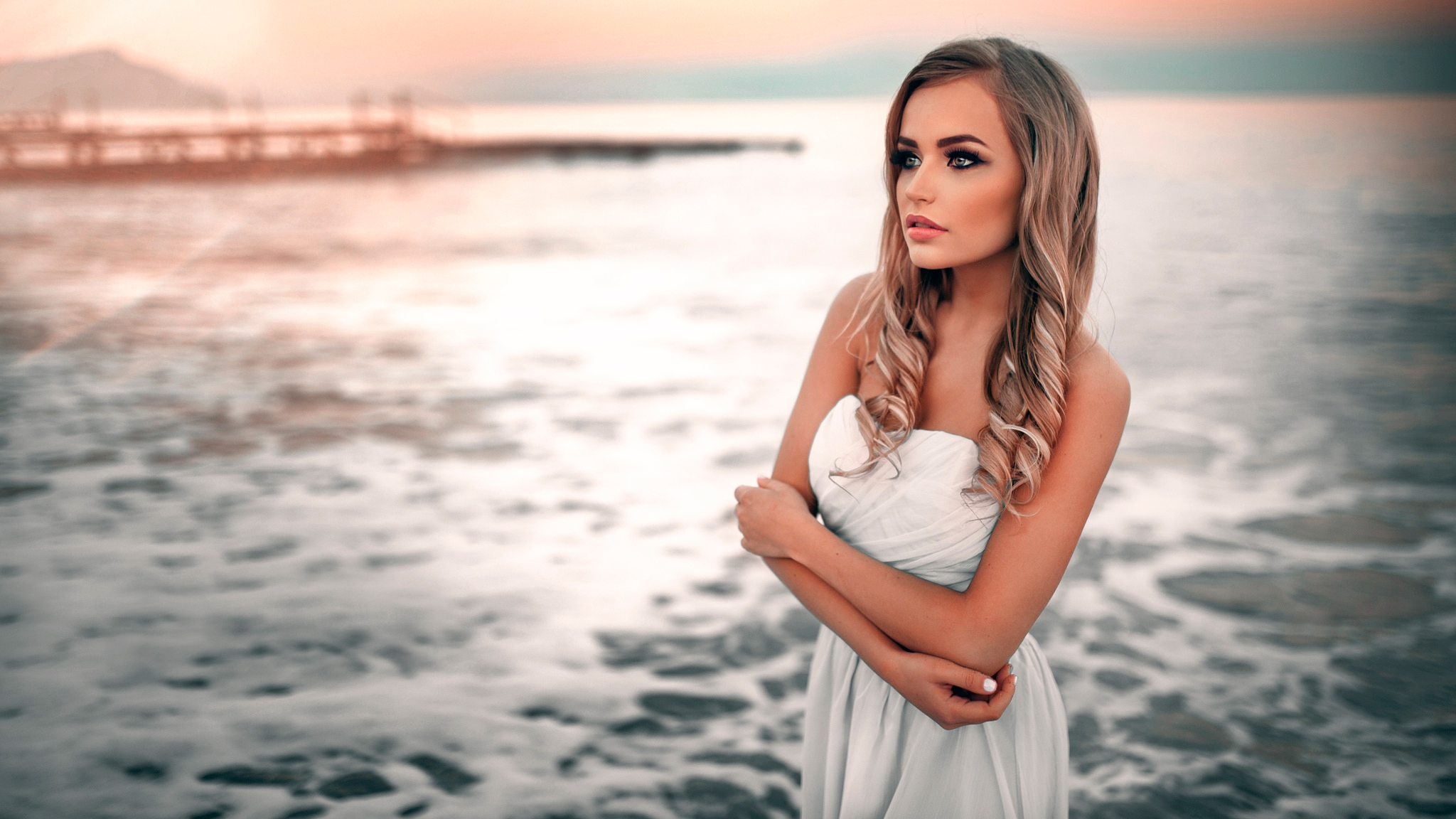 Красивая молодая девушка в белом вечернем платье на закате