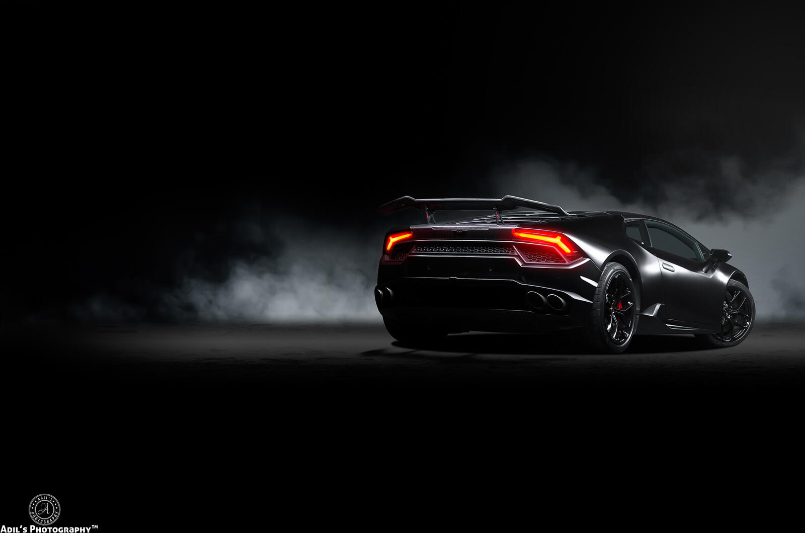 Free photo The Lamborghini Huracan stands backwards in the dark.