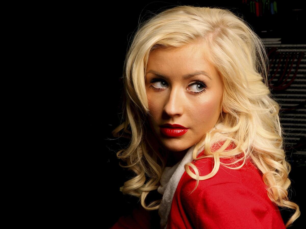 Блондинка Кристина Агилера в красном на темном фоне