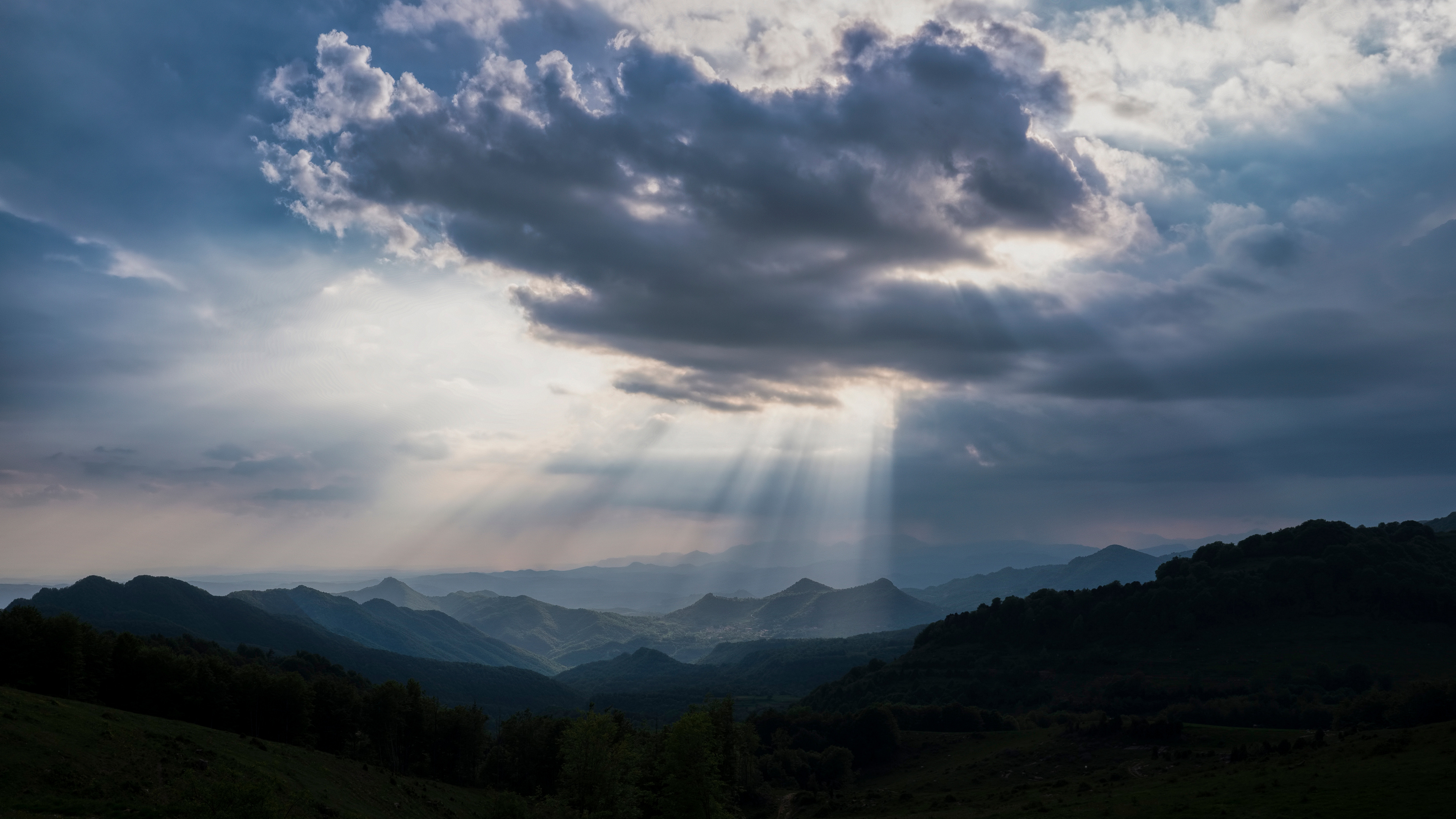 Бесплатное фото Солнечные лучи падают на вершины холмов