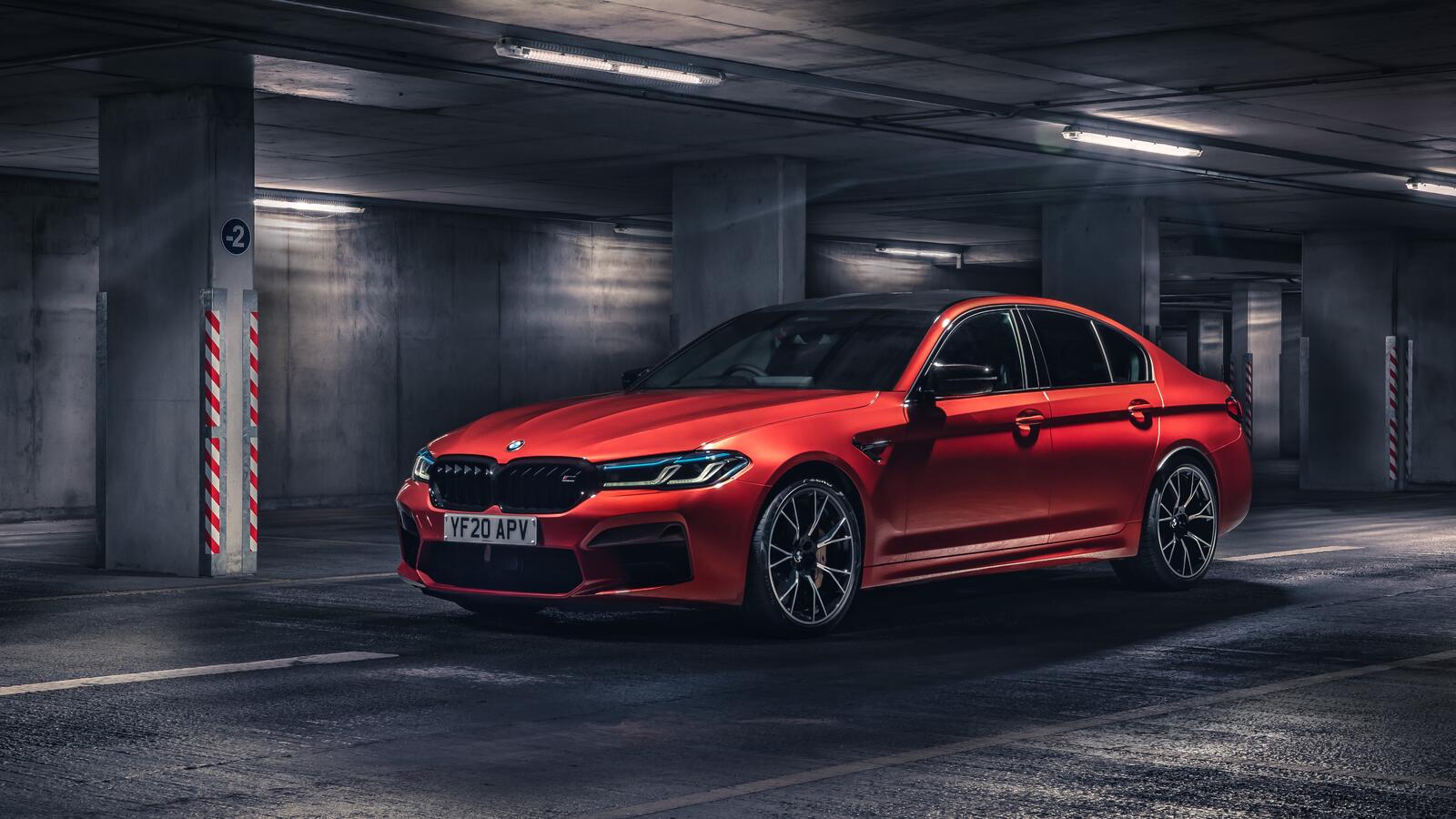 Free photo Red BMW M5 F90 in the underground parking lot