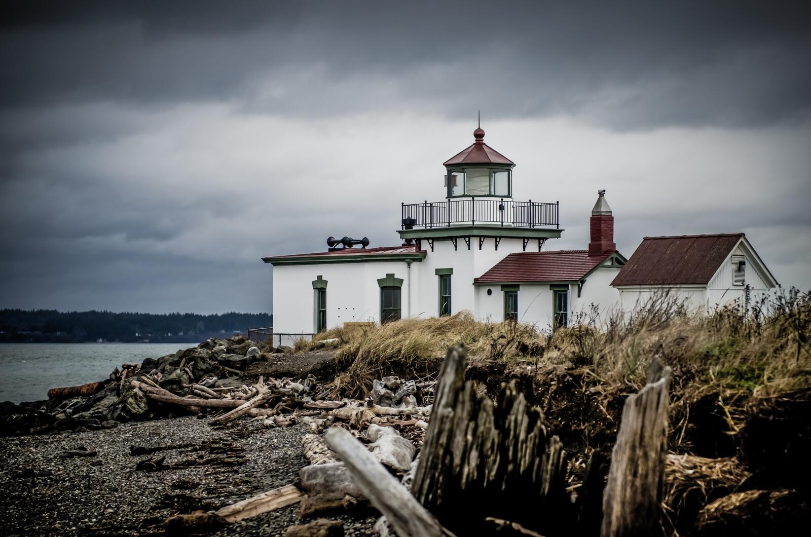 Free photo House with a lighthouse located on the bluff of the ocean shore