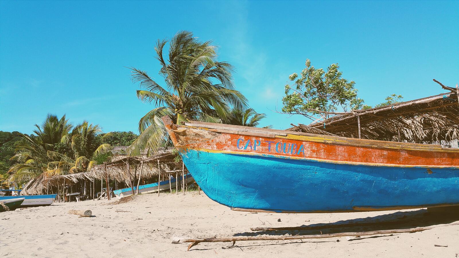 免费照片在有棕榈树的海滩上的一艘废弃的旧船